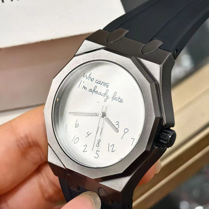 Luksuzna moška ura z osmerokotnim ohišjem in silikonskim pasom, vodotesna, opremljena s številčnico, na kateri je natisnjen duhovit slogan »Who Cares I'm Already Late« (Kaj pa, saj sem že zamudil).